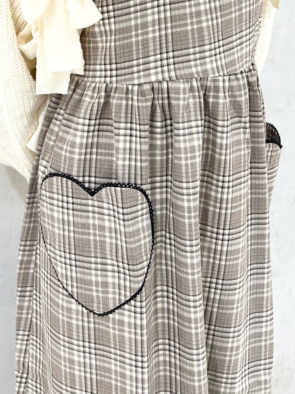 ベージュ系のワンピース、ホワイト系のシャツ/ブラウス、ホワイト系のカーディガン/ボレロを着用したレディースの秋コーディネートの7枚目の写真