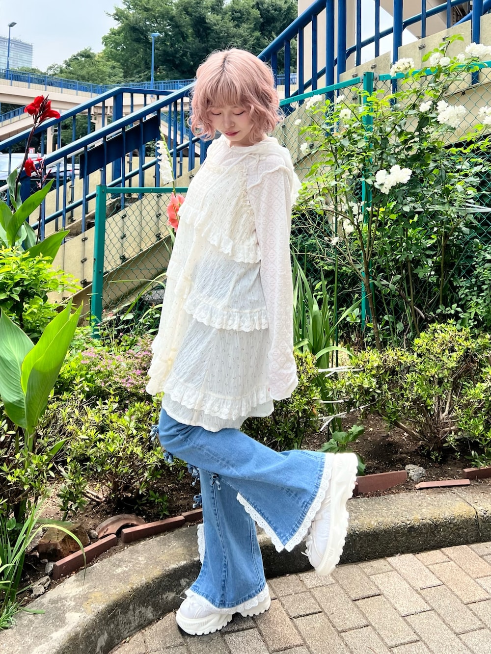 ホワイト系のチュニック、ホワイト系のTシャツ/カットソー、ブルー系のデニムパンツを着用したレディースの夏コーディネートの3枚目の写真