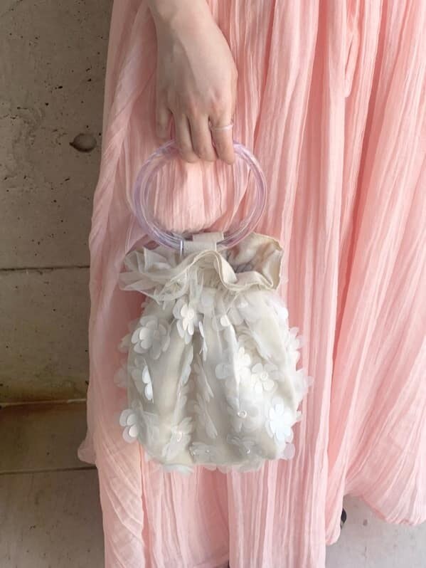 ブラック系のパンプス、ホワイト系のハンドバッグ、ピンク系のワンピースを着用したレディースの春コーディネートの6枚目の写真