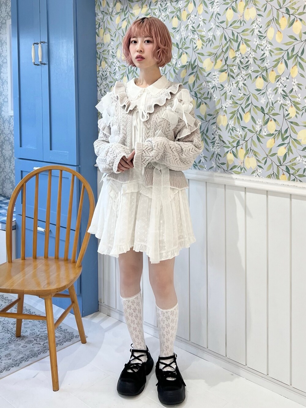 グレー系のカーディガン/ボレロ、ホワイト系のシャツ/ブラウス、ホワイト系のスカートを着用したレディースの冬コーディネートの2枚目の写真