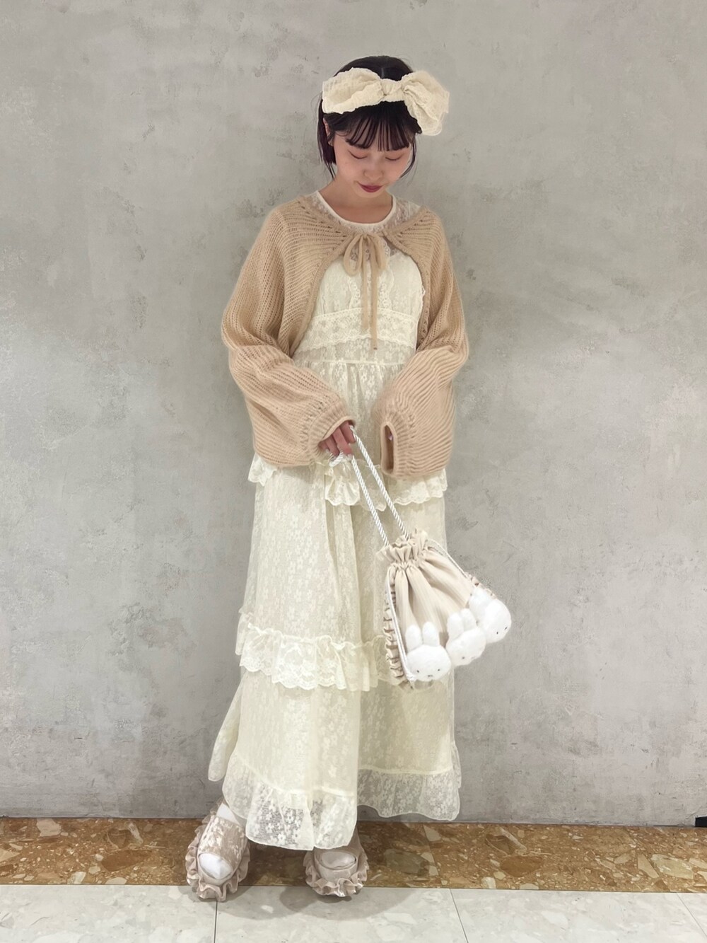 ベージュ系のカーディガン/ボレロ、ホワイト系のワンピース、ホワイト系のショルダーバッグを着用したレディースの夏コーディネートの5枚目の写真