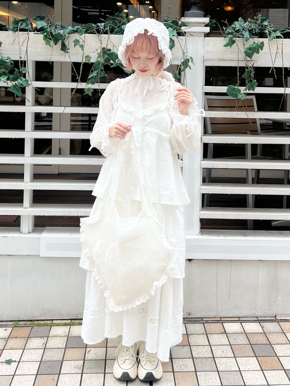 ホワイト系のワンピース、ホワイト系のTシャツ/カットソー、ホワイト系のトートバッグを着用したレディースの冬コーディネートの3枚目の写真