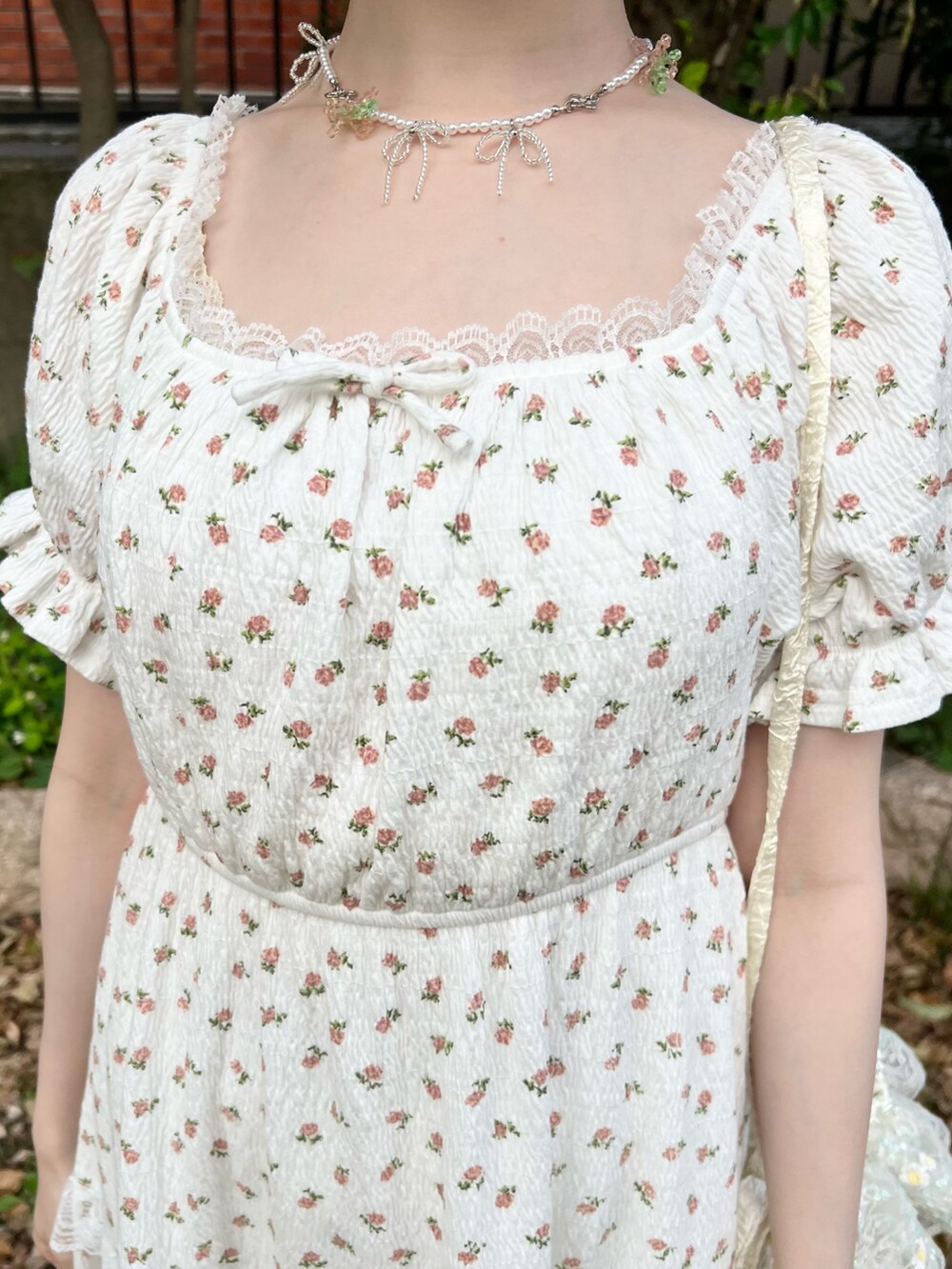 ホワイト系のワンピース、ホワイト系のショルダーバッグ、ベージュ系のサンダルを着用したレディースの春コーディネートの7枚目の写真