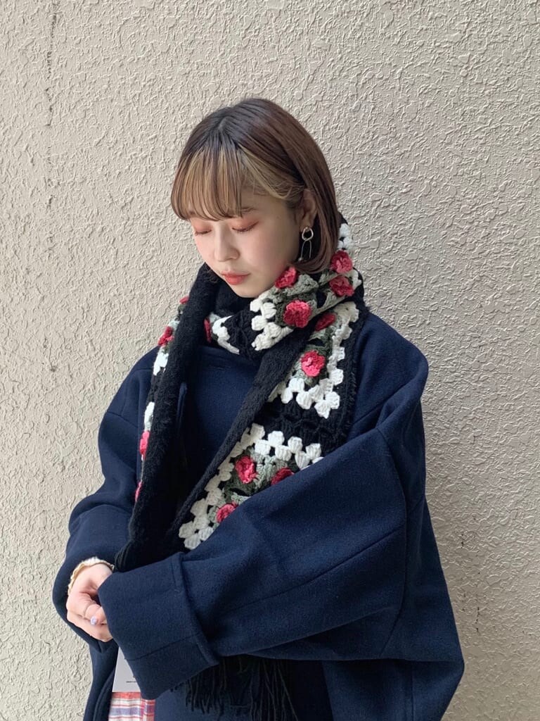 ブルー系のチェスターコート、ホワイト系のニット/セーター、レッド系のスカートを着用したレディースの秋コーディネートの6枚目の写真