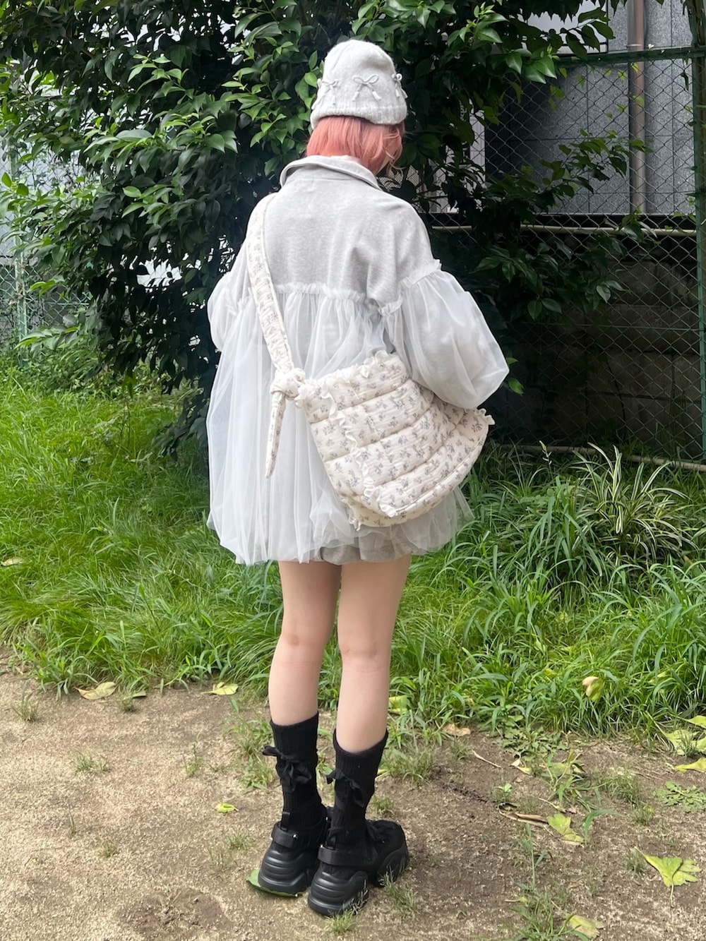 グレー系のスウェット、ピンク系のニット/セーター、ブルー系のショルダーバッグを着用したレディースの秋コーディネートの4枚目の写真