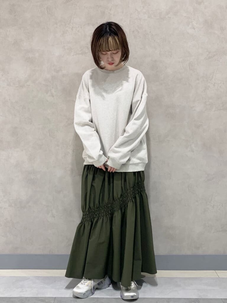 ベージュ系のスカート、ホワイト系のスニーカー、ホワイト系のスウェットを着用したレディースの冬コーディネートの3枚目の写真
