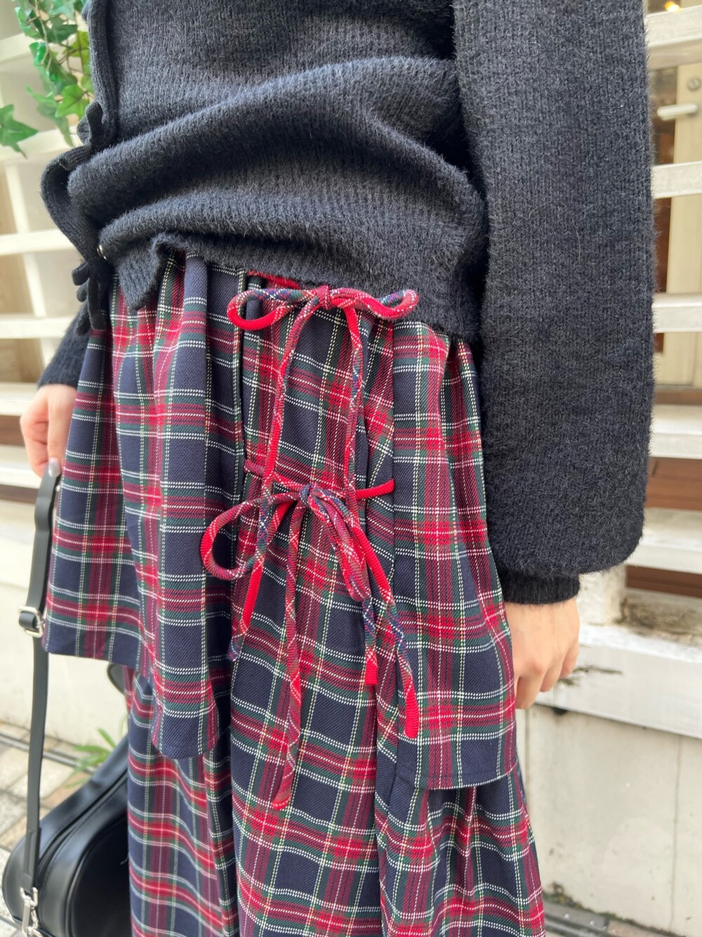 ブルー系のニット/セーター、ブルー系のスカート、ブラック系のスニーカーを着用したレディースの秋コーディネートの6枚目の写真