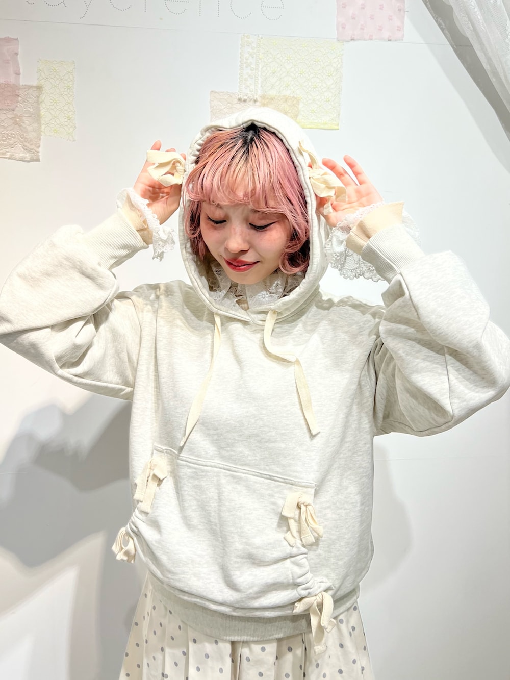 グレー系のパーカー、ホワイト系のスカート、ブルー系のショルダーバッグを着用したレディースの秋コーディネートの4枚目の写真