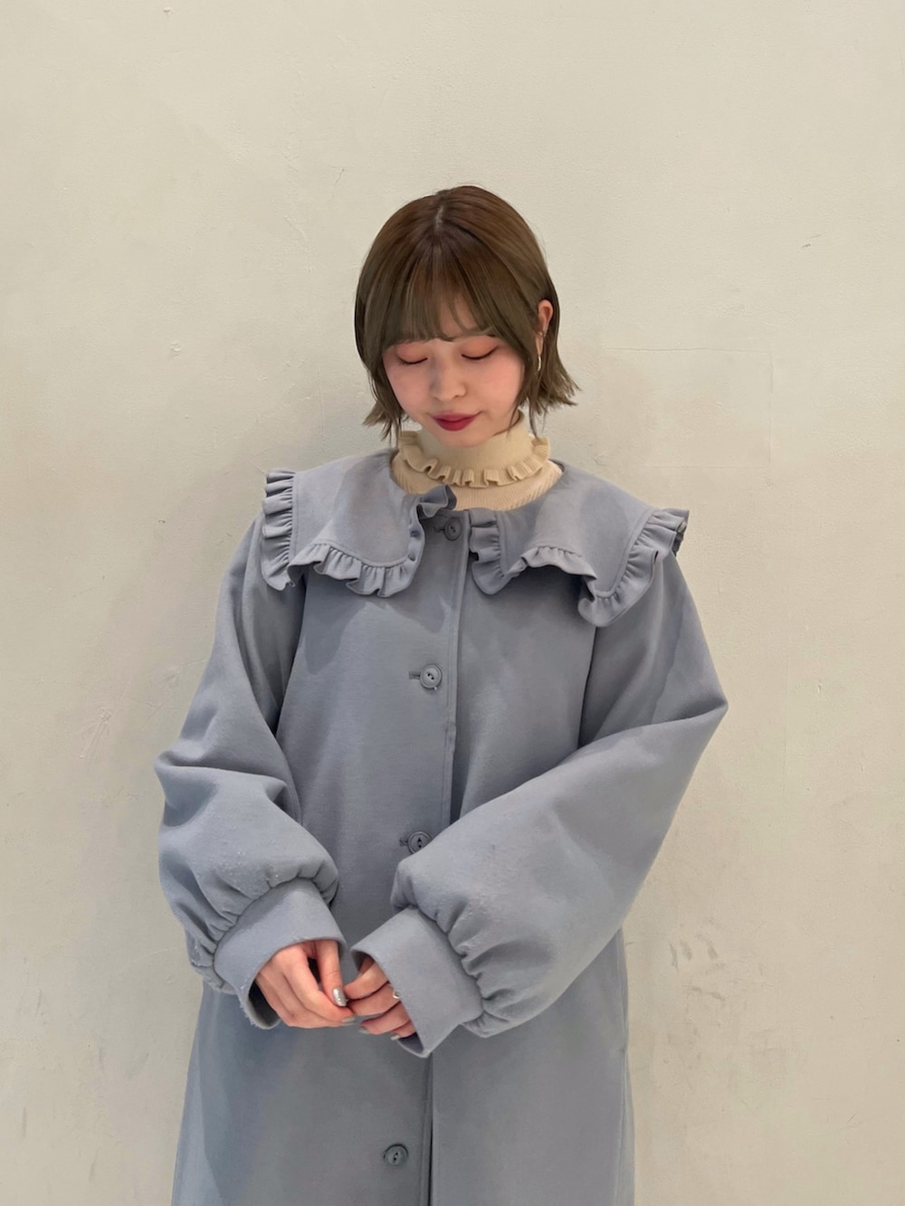 ブラック系のローファー、ブルー系のその他アウター、ホワイト系のニット/セーターを着用したレディースの冬コーディネートの6枚目の写真