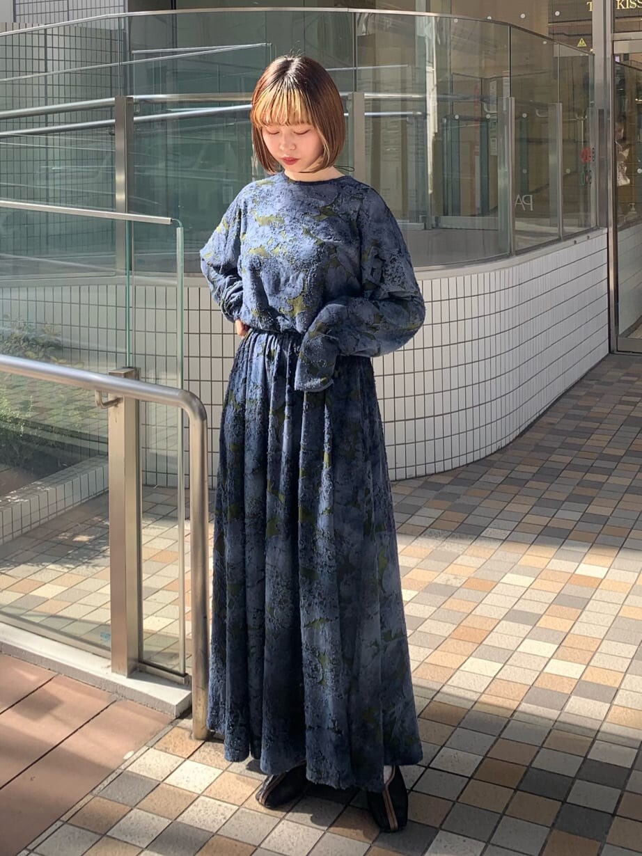 ブラック系のカーディガン/ボレロ、ブラック系のパンプス、ブルー系のワンピースを着用したレディースの冬コーディネートの6枚目の写真