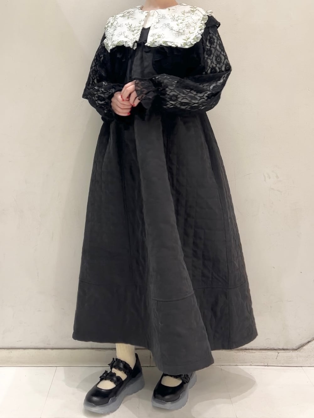 ブラック系のワンピース、ブラック系のカーディガン/ボレロ、ブラック系のスニーカーを着用したレディースの冬コーディネートの4枚目の写真