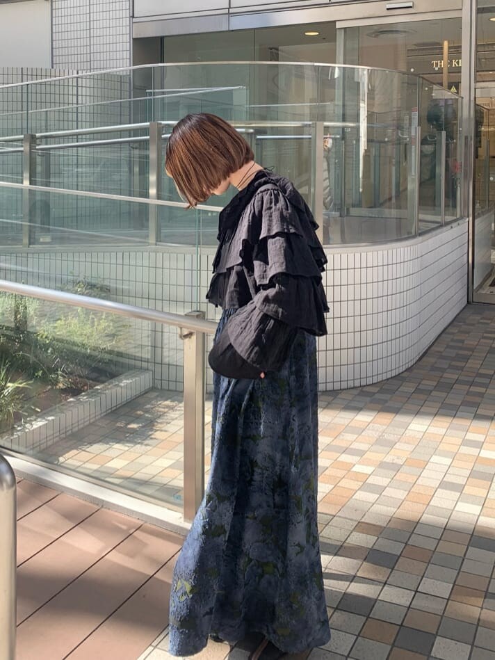 ブラック系のカーディガン/ボレロ、ブラック系のパンプス、ブルー系のワンピースを着用したレディースの冬コーディネートの4枚目の写真