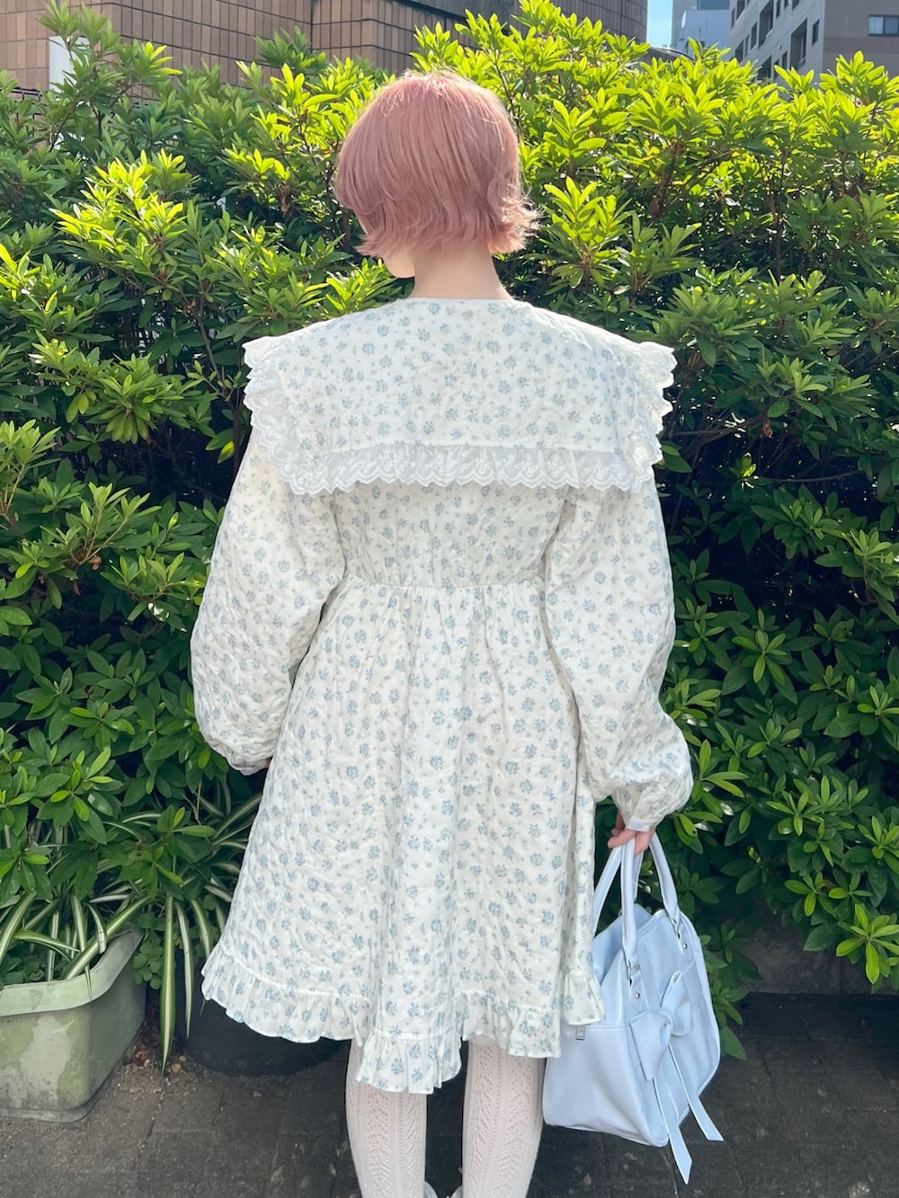 ホワイト系のワンピース、ブルー系のハンドバッグ、ブルー系のブーツを着用したレディースの夏コーディネートの7枚目の写真
