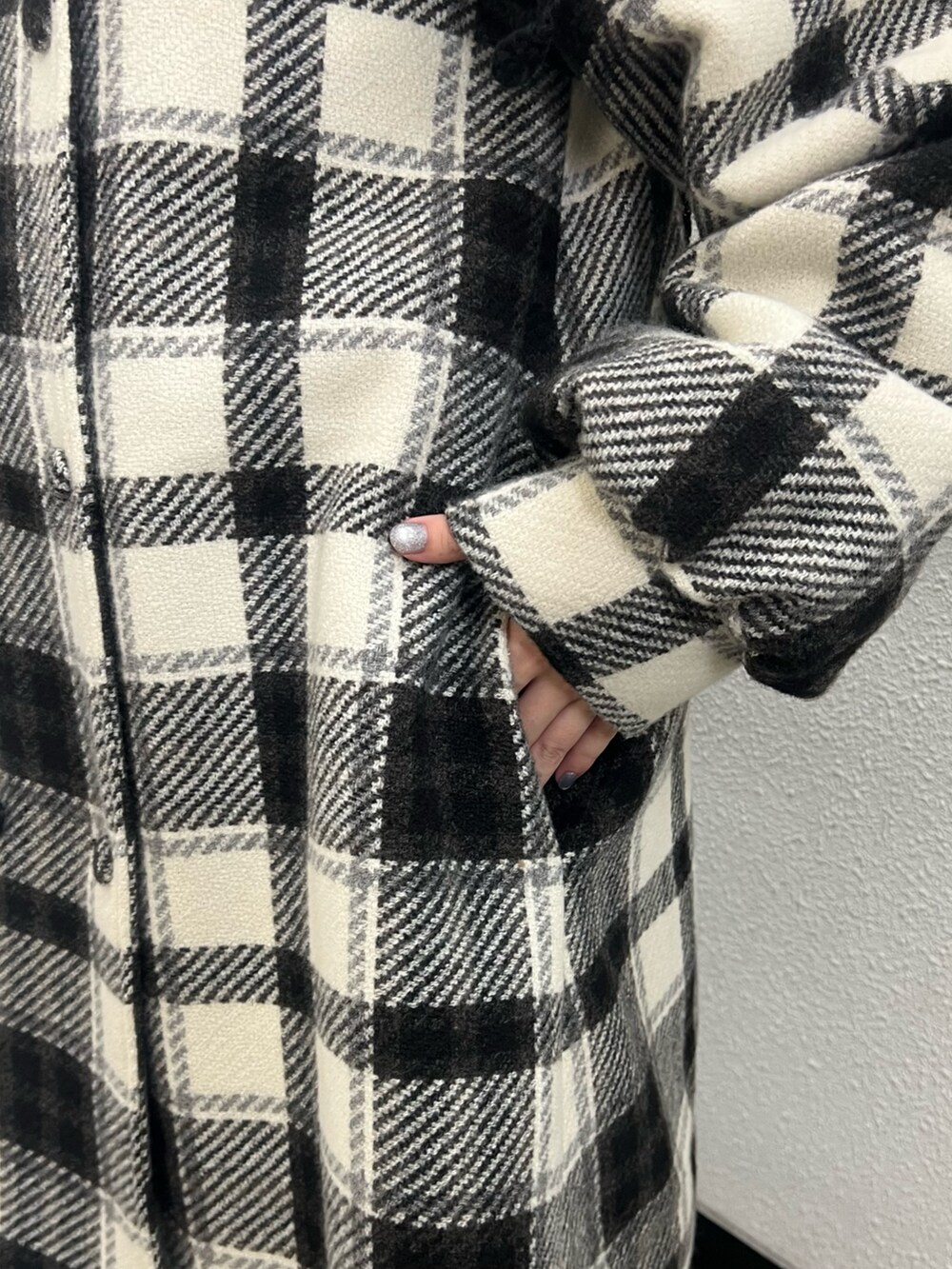 ブラック系のチェスターコート、ホワイト系のニット/セーター、ブラック系のハンドバッグを着用したレディースの秋コーディネートの8枚目の写真