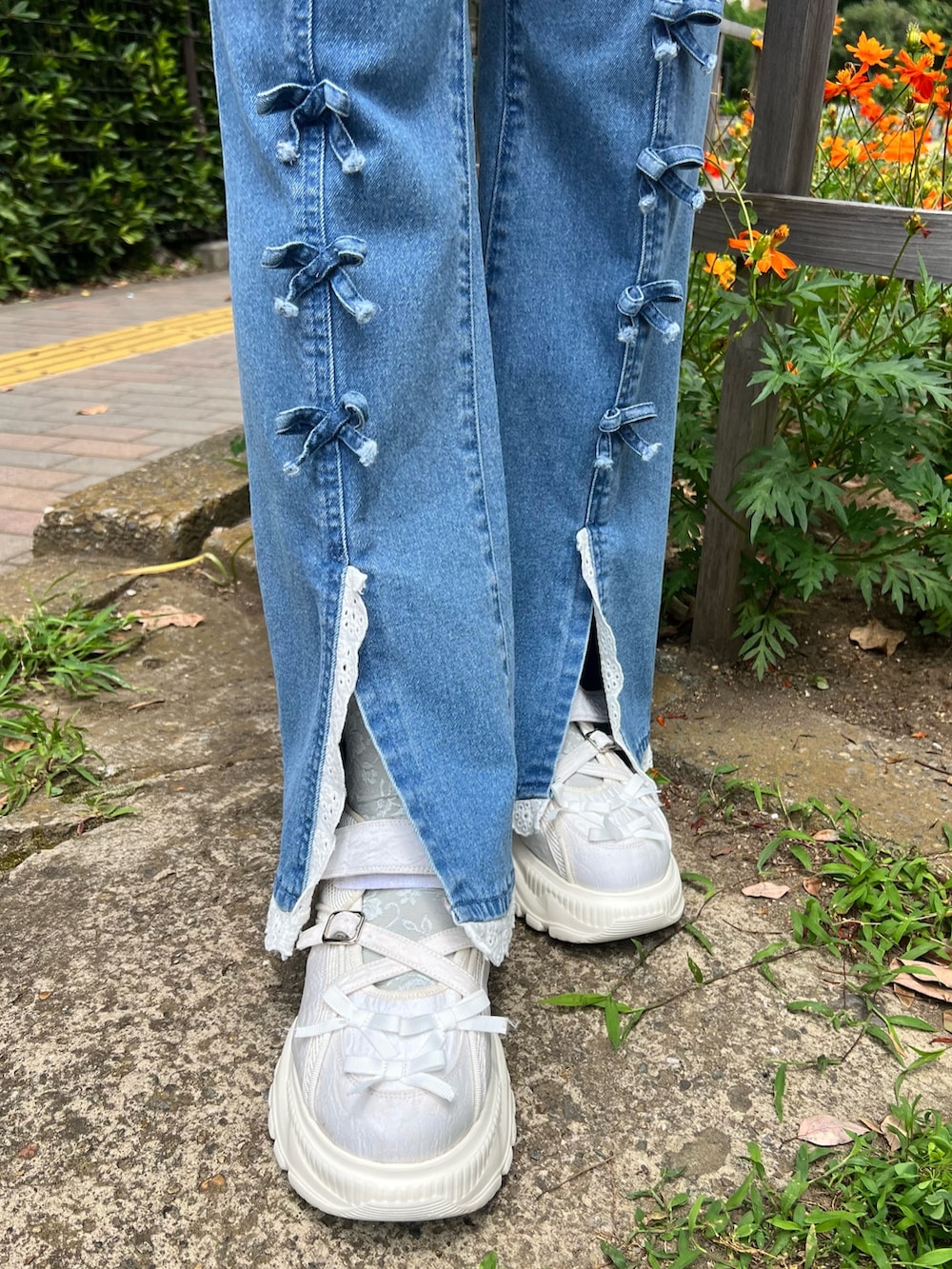 ホワイト系のチュニック、ホワイト系のTシャツ/カットソー、ブルー系のデニムパンツを着用したレディースの夏コーディネートの10枚目の写真