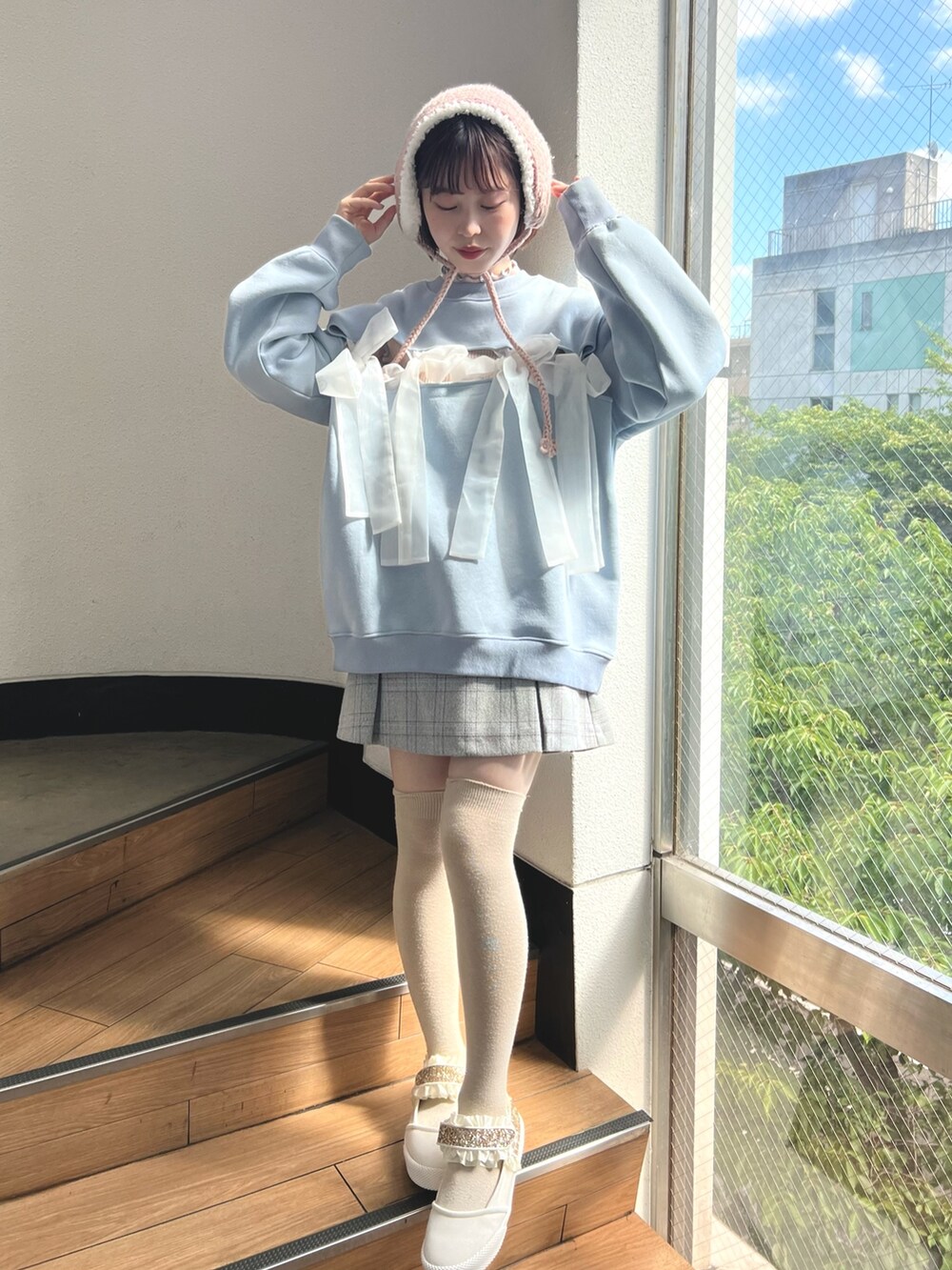 ブルー系のスウェット、グレー系のスカート、ピンク系のニット/セーターを着用したレディースの夏コーディネートの2枚目の写真