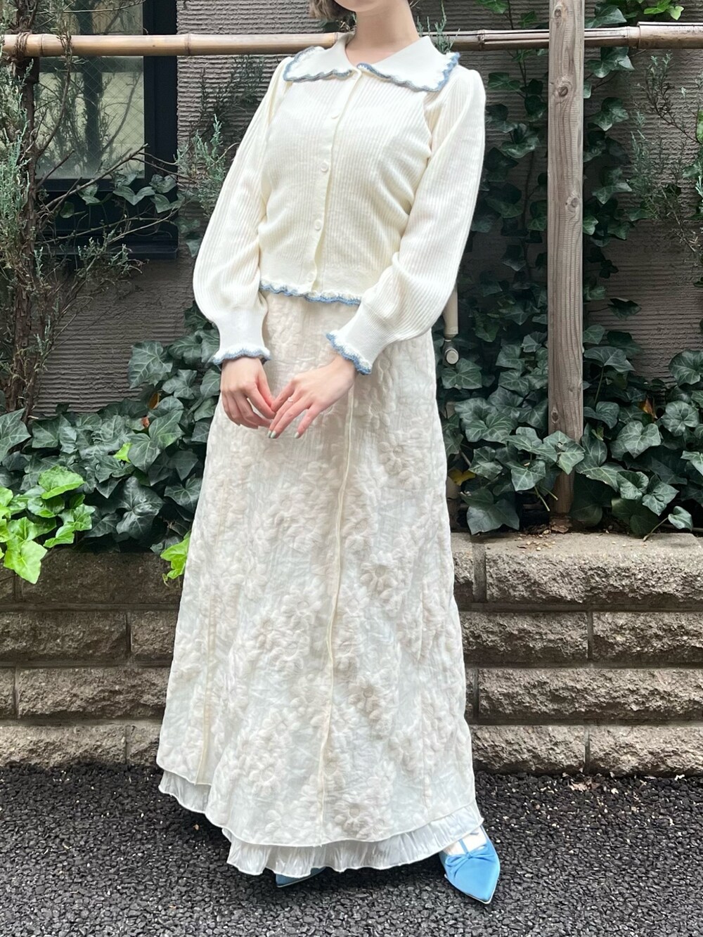 ホワイト系のニット/セーター、ホワイト系のワンピース、ブルー系のパンプスを着用したレディースの冬コーディネートの7枚目の写真