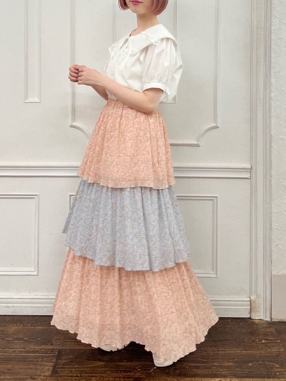 ホワイト系のシャツ/ブラウス、ピンク系のスカート、ホワイト系のスニーカーを着用したレディースの夏コーディネートの2枚目の写真