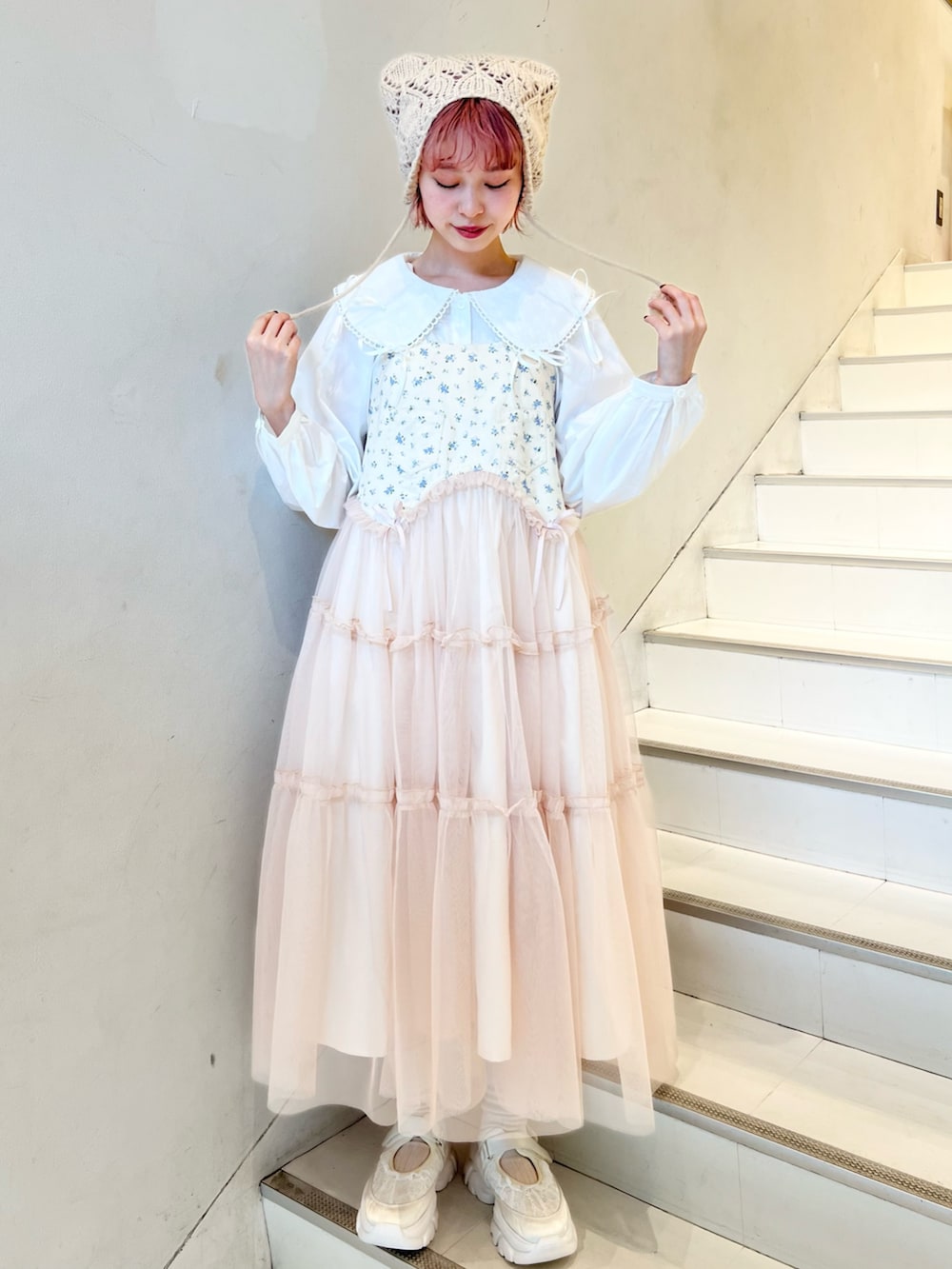 ピンク系のカーディガン/ボレロ、ホワイト系のシャツ/ブラウス、ピンク系のワンピースを着用したレディースの冬コーディネートの4枚目の写真