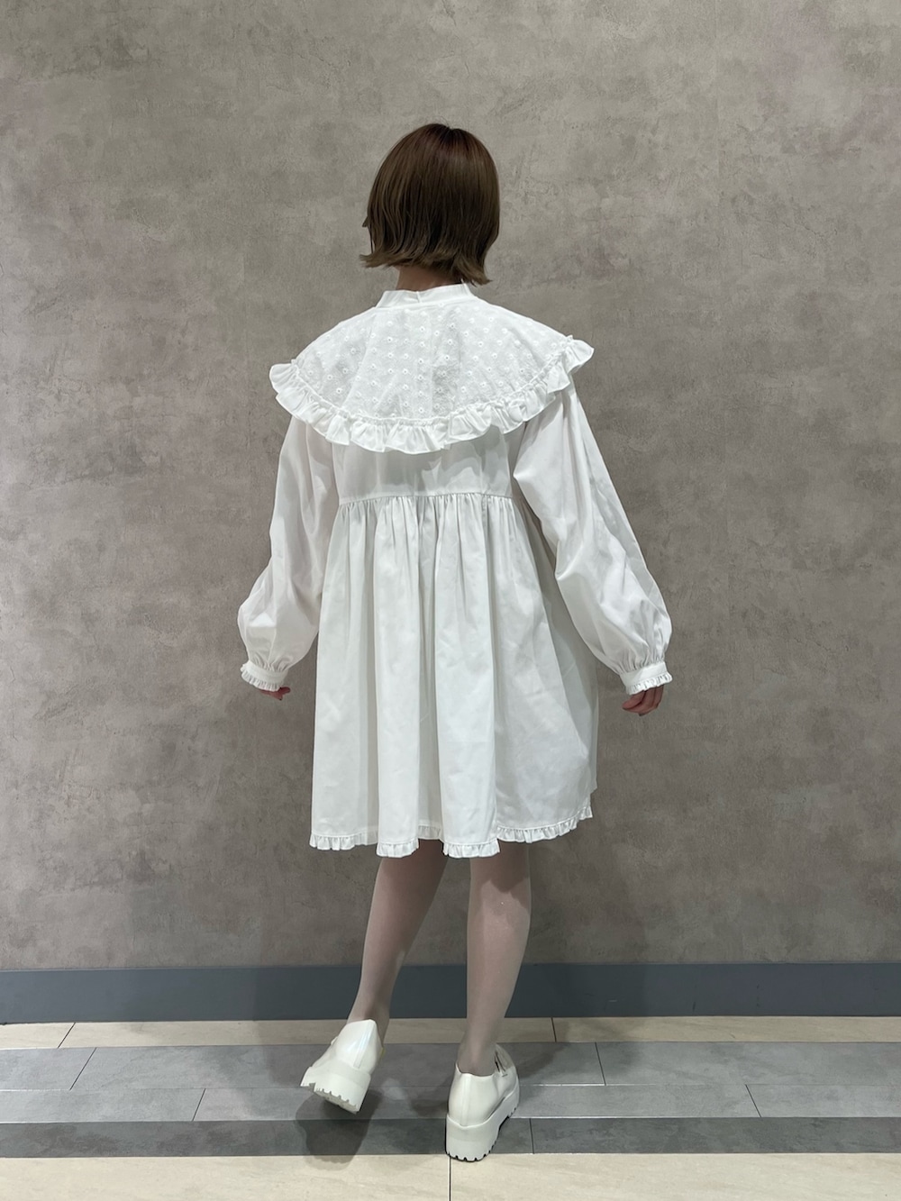 ブルー系のその他アウター、ホワイト系のワンピース、ホワイト系のローファーを着用したレディースの冬コーディネートの6枚目の写真