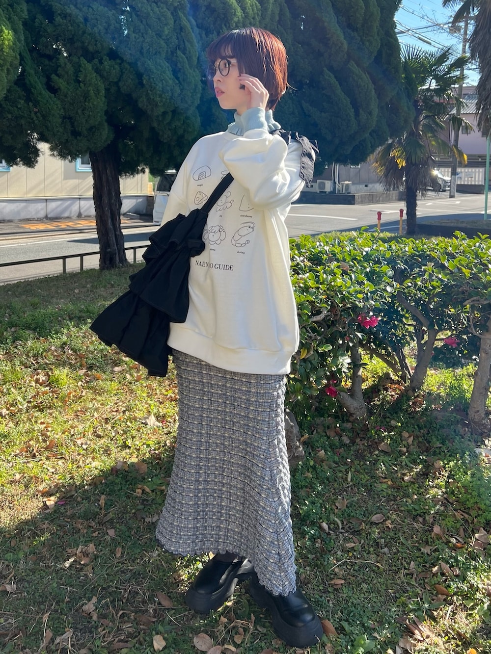 ブルー系のニット/セーター、ホワイト系のスウェット、ブラック系のトートバッグを着用したレディースの冬コーディネートの4枚目の写真