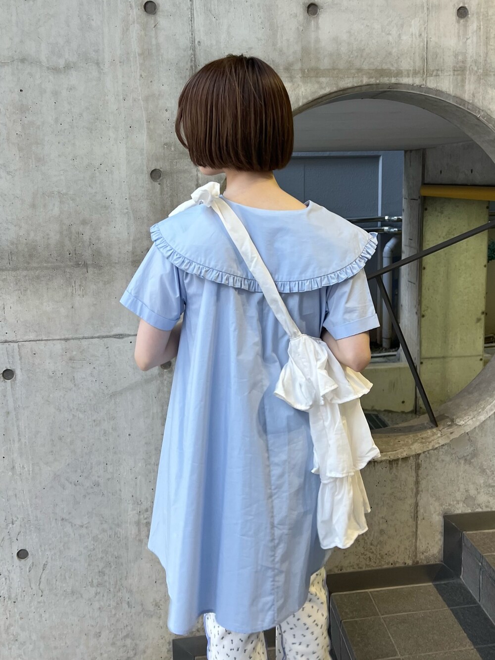 ホワイト系のトートバッグ、ブルー系のスニーカー、ブルー系のその他パンツを着用したレディースの春コーディネートの4枚目の写真