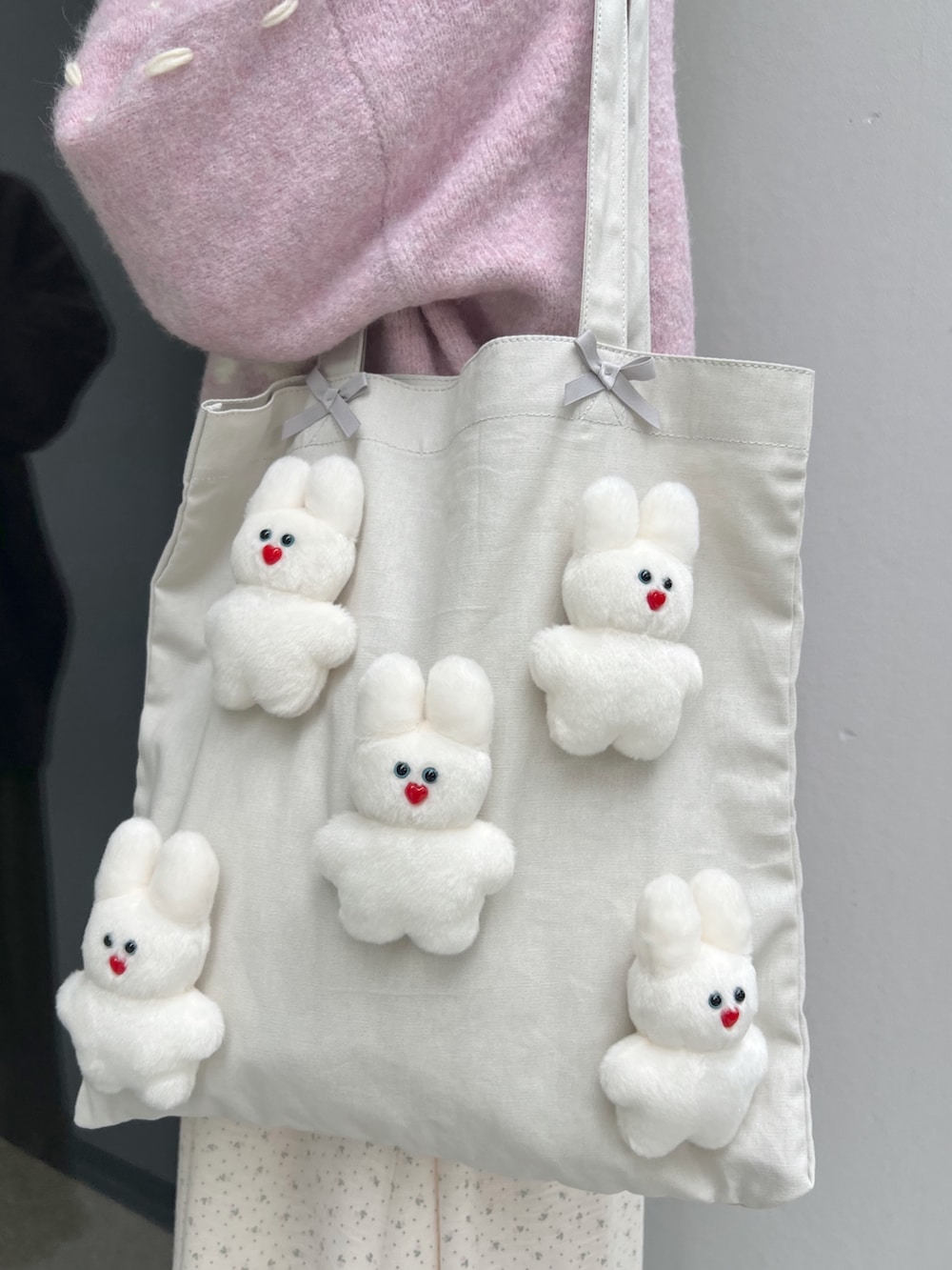 ホワイト系のブーツ、ピンク系のカーディガン/ボレロ、ホワイト系のトートバッグを着用したレディースの秋コーディネートの8枚目の写真