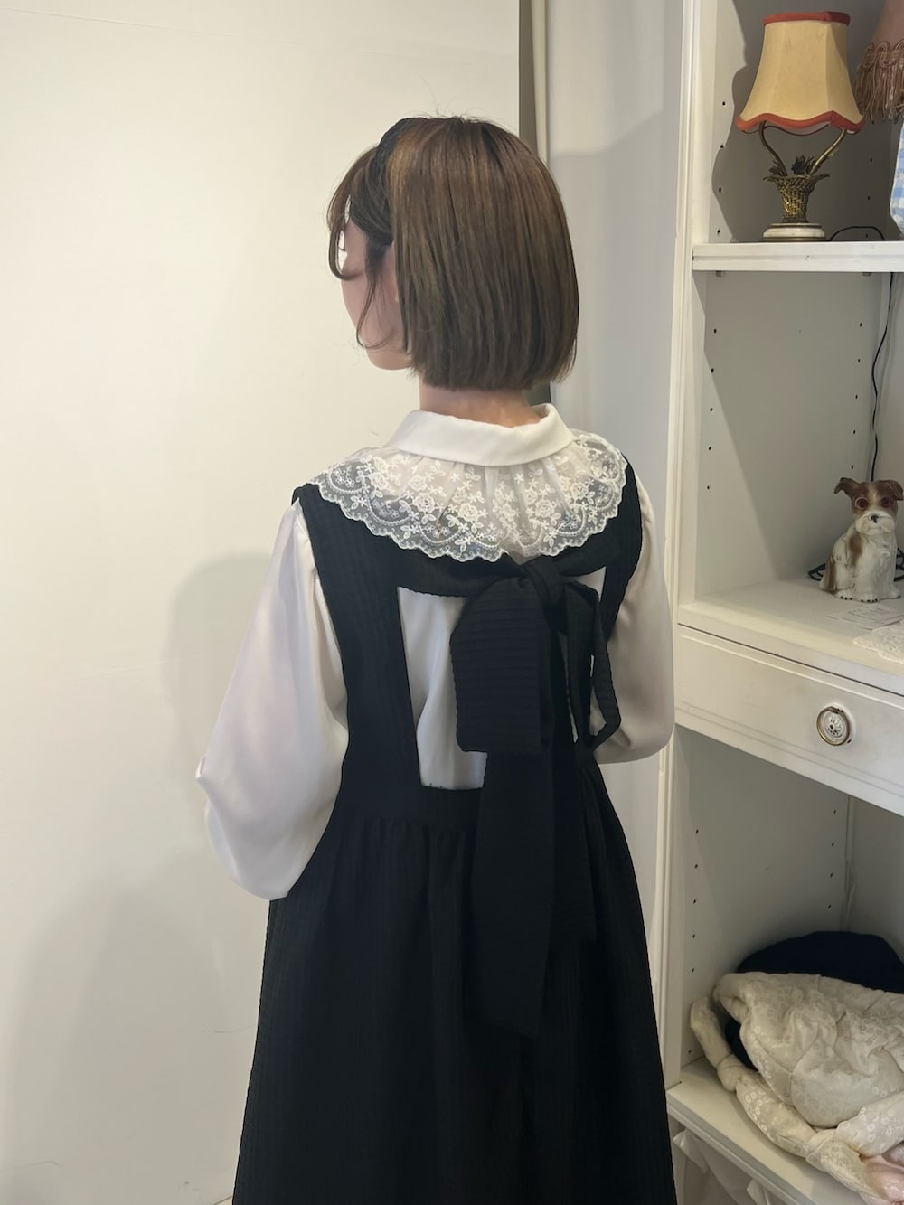 ホワイト系のチュニック、ブラック系のサンダル、ブラック系のワンピースを着用したレディースの春コーディネートの5枚目の写真