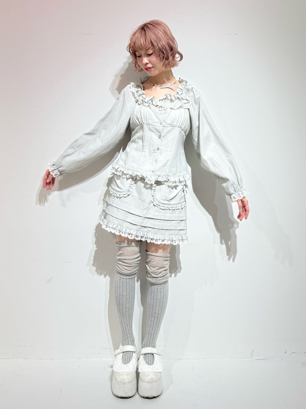 ブルー系のシャツ/ブラウス、ブルー系のスカート、ホワイト系のスニーカーを着用したレディースの冬コーディネートの2枚目の写真