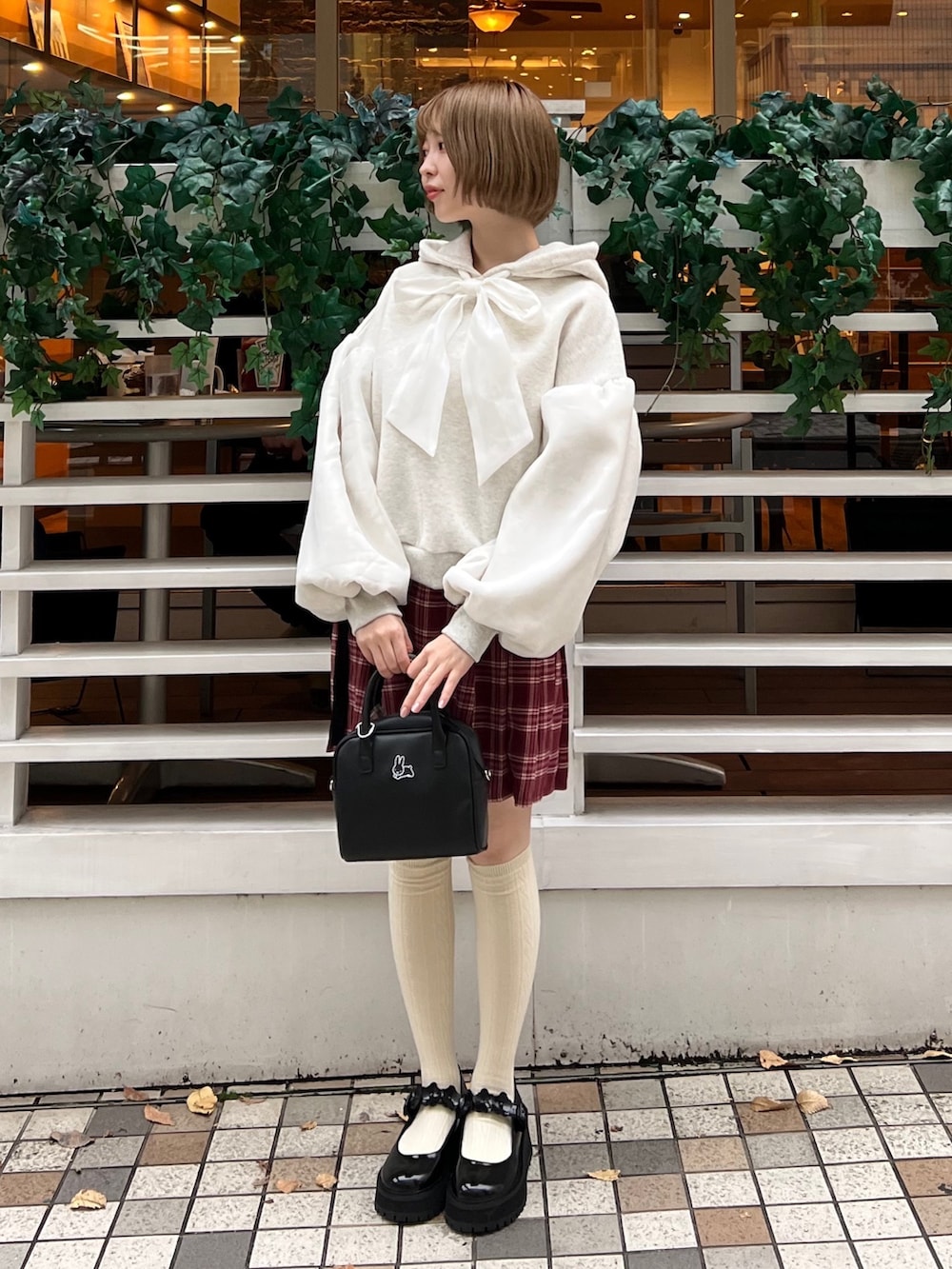 ブラック系のローファー、ホワイト系のパーカー、ブラック系のボストンバッグを着用したレディースの冬コーディネートの4枚目の写真