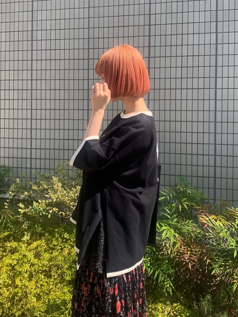 ブラック系のパンプス、ブラック系のスカート、ブラック系のトートバッグを着用したレディースの春コーディネートの4枚目の写真