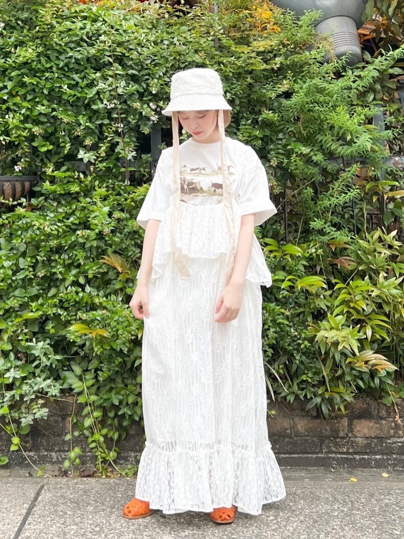 オレンジ系のパンプス、ホワイト系のスカート、ベージュ系のTシャツ/カットソーを着用したレディースの夏コーディネートの2枚目の写真