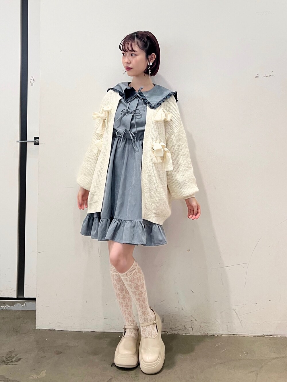 ブルー系のワンピース、ホワイト系のカーディガン/ボレロ、ホワイト系のスニーカーを着用したレディースの秋コーディネートの2枚目の写真