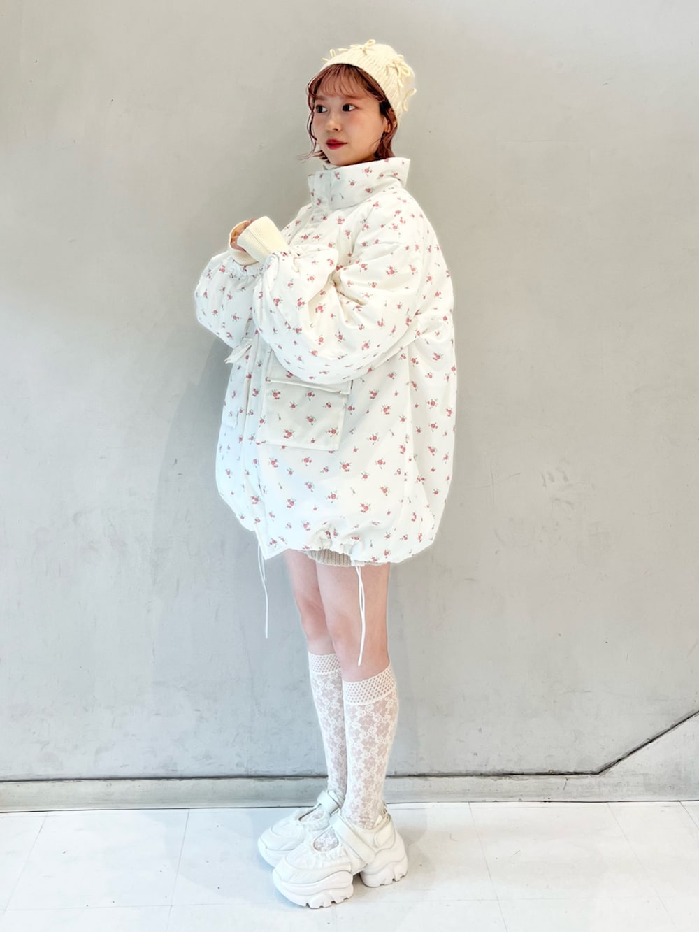 ピンク系のブルゾン、ベージュ系のスウェットパンツ、ホワイト系のニット/セーターを着用したレディースの冬コーディネートの3枚目の写真