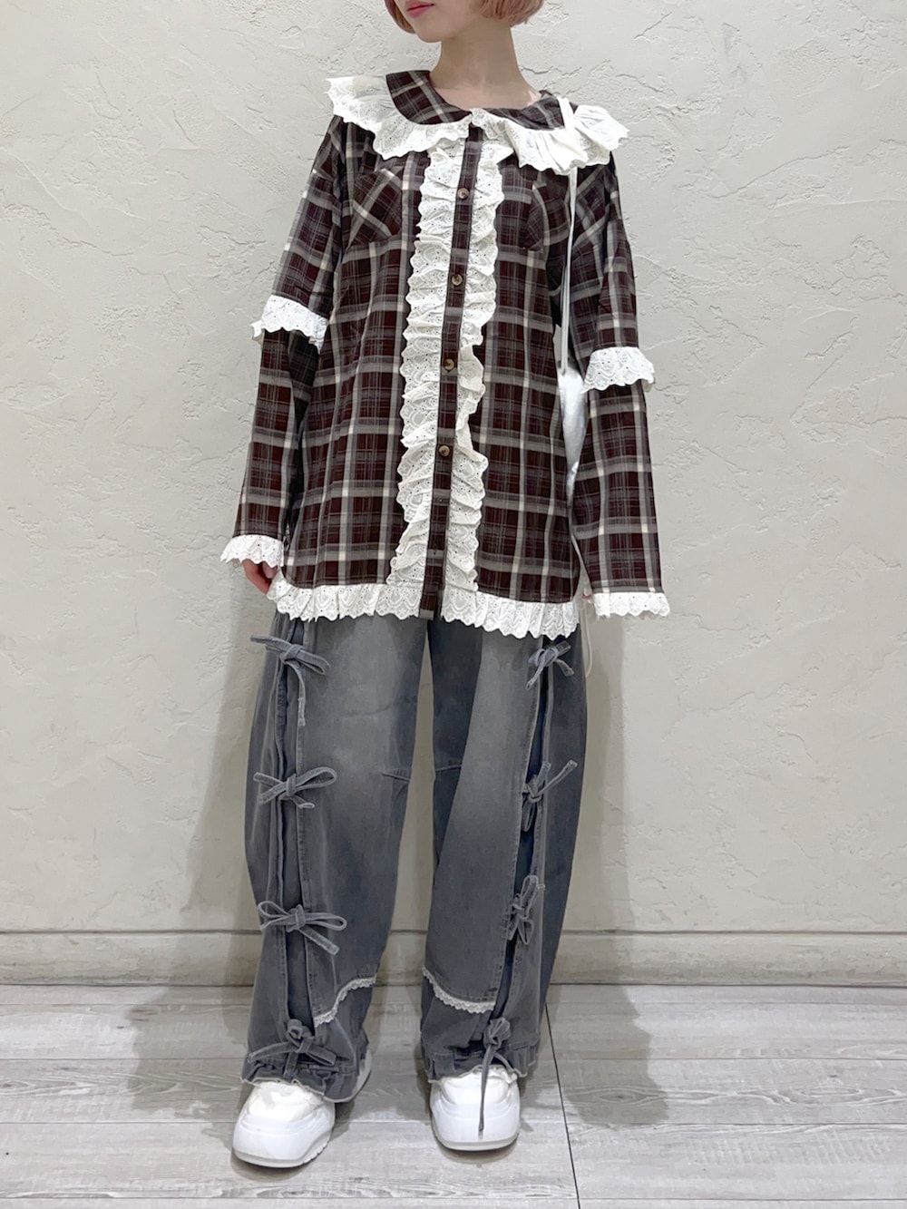 ブラウン系のシャツ/ブラウス、グレー系のデニムパンツ、ホワイト系のスニーカーを着用したレディースの秋コーディネートの8枚目の写真