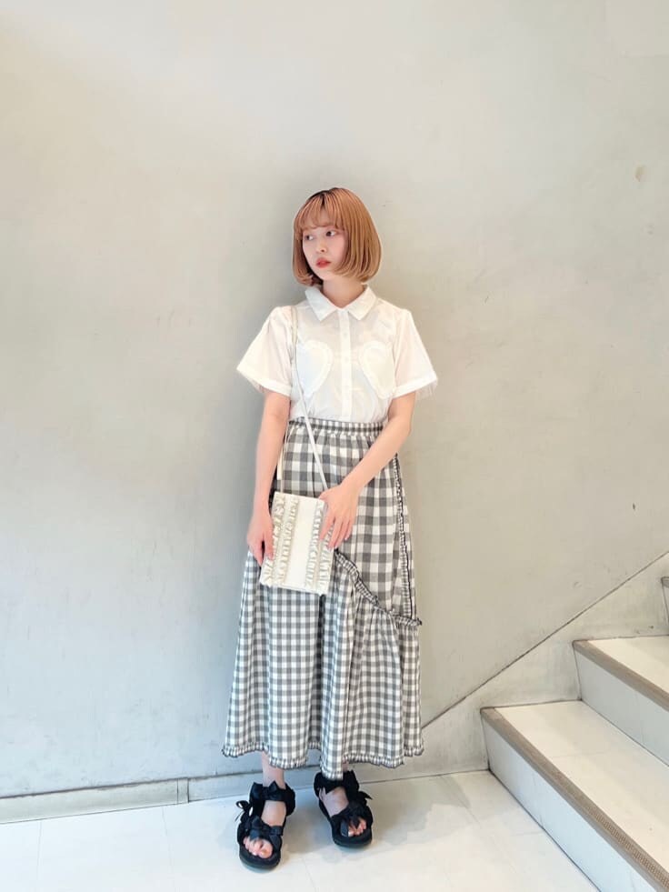 ホワイト系のショルダーバッグ、ブラック系のスカート、ブラック系のサンダルを着用したレディースの夏コーディネートの3枚目の写真