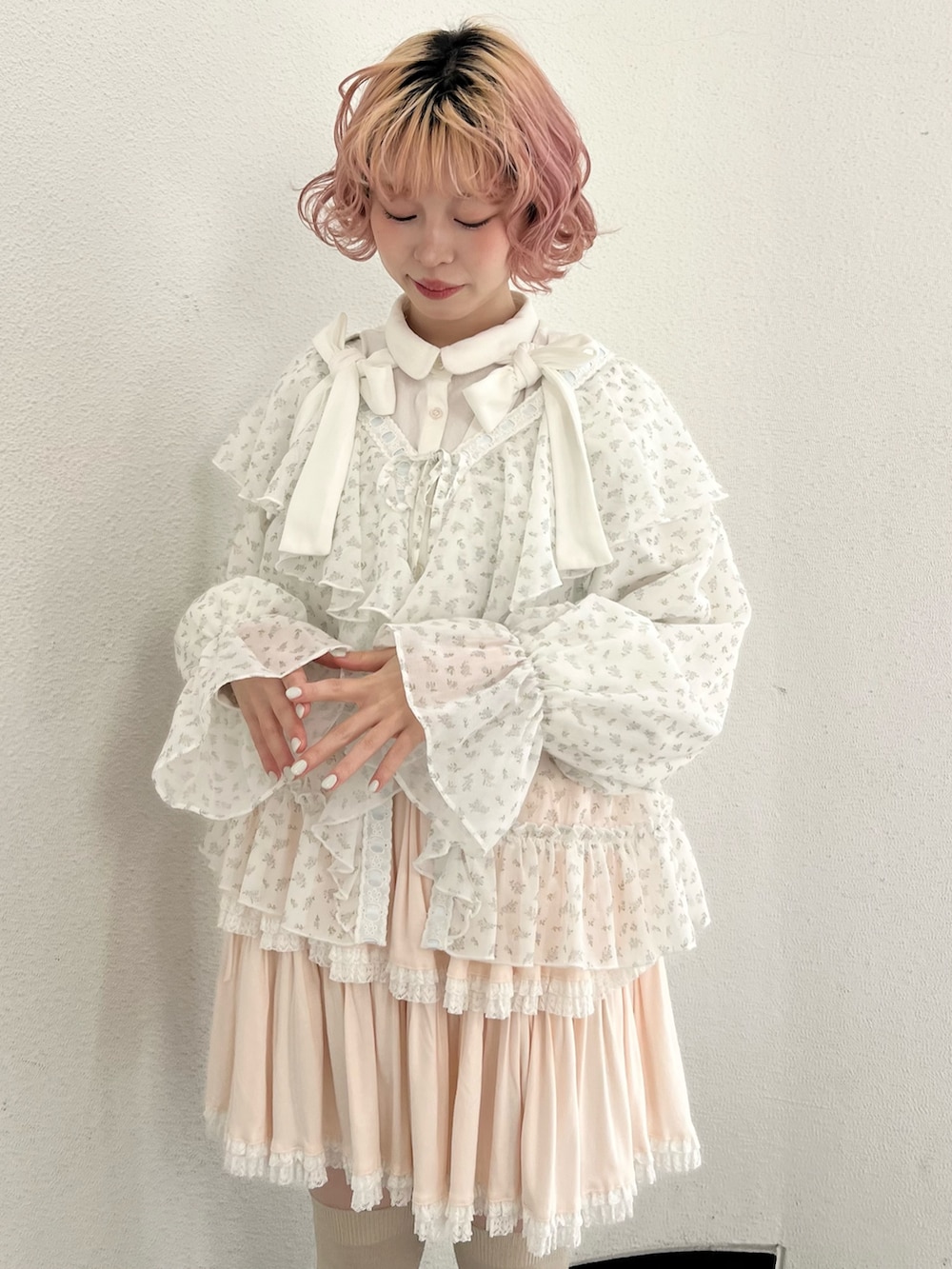 ブルー系のカーディガン/ボレロ、ピンク系のスカート、ホワイト系のスニーカーを着用したレディースの冬コーディネートの6枚目の写真