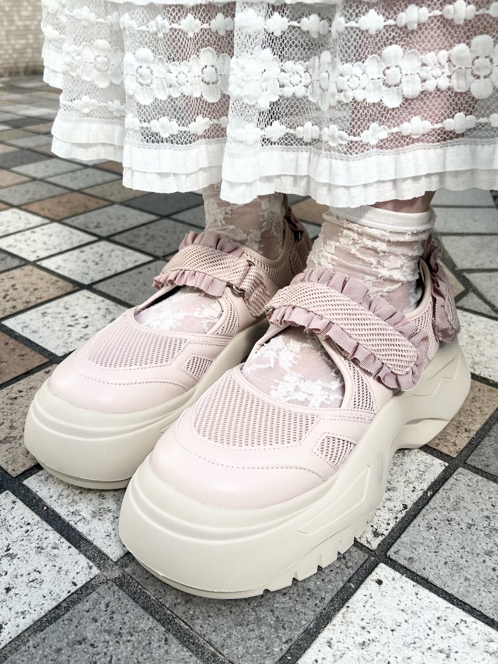 ホワイト系のスカート、ホワイト系のTシャツ/カットソー、ピンク系のスニーカーを着用したレディースの秋コーディネートの7枚目の写真