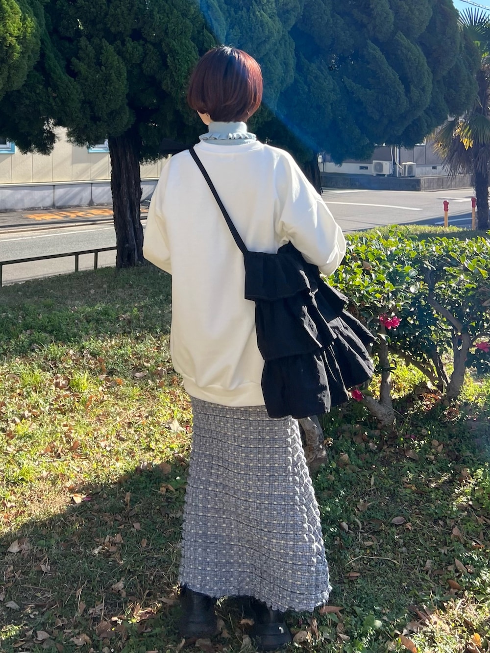 ブルー系のニット/セーター、ホワイト系のスウェット、ブラック系のトートバッグを着用したレディースの冬コーディネートの7枚目の写真