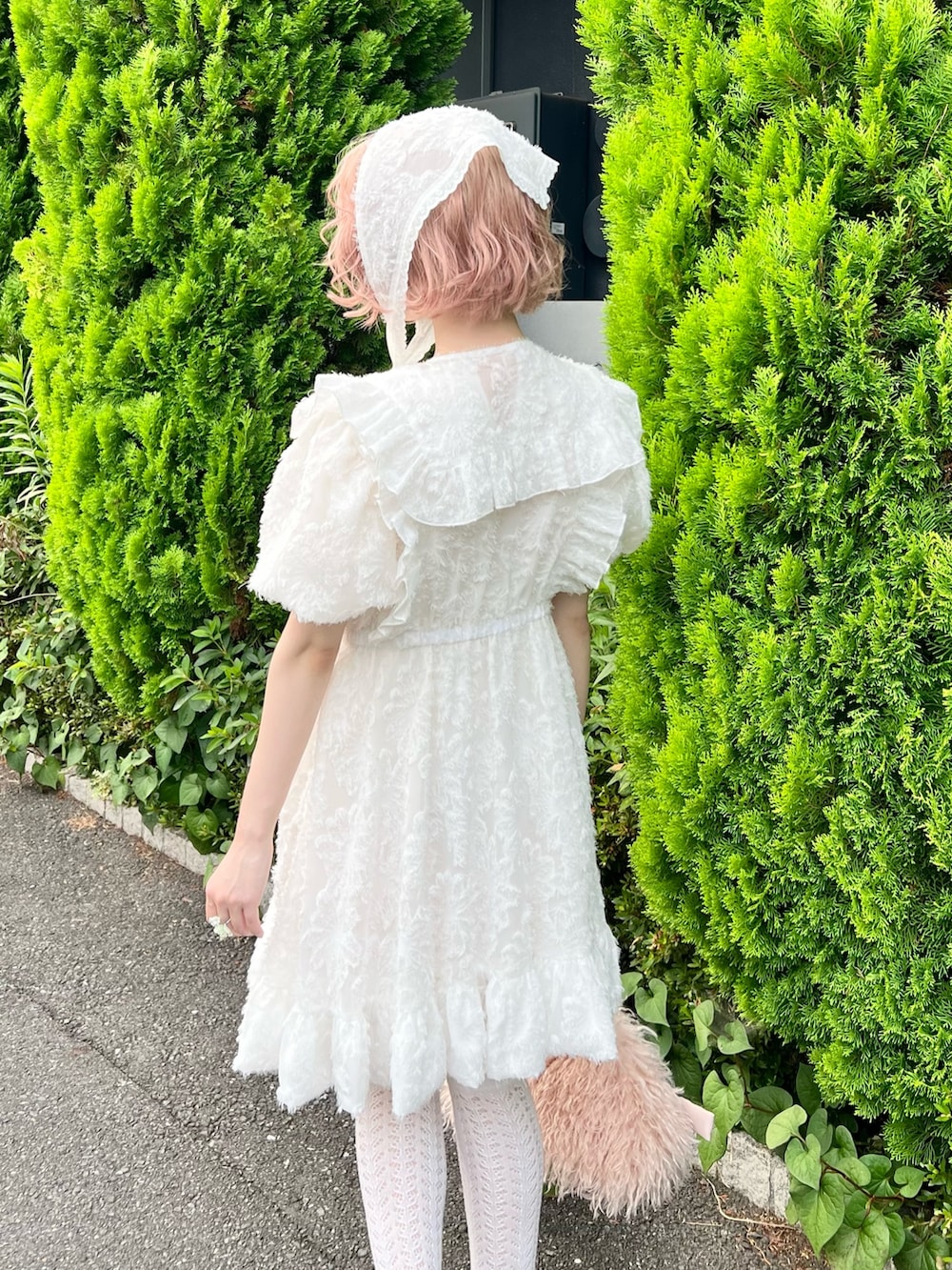 ホワイト系のワンピース、ピンク系のボストンバッグ、ピンク系のローファーを着用したレディースの夏コーディネートの9枚目の写真