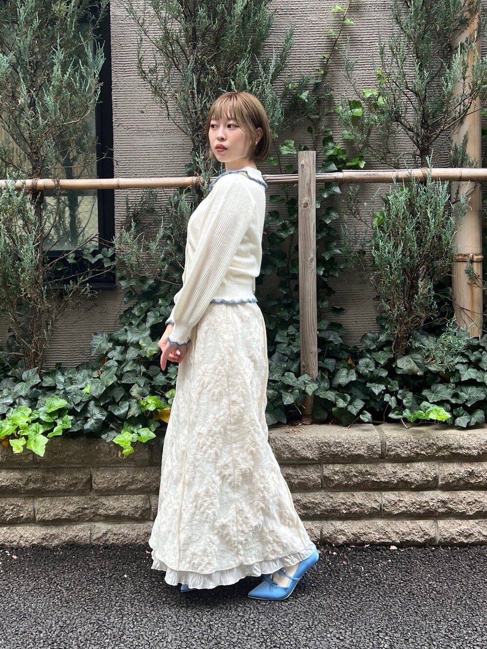 ホワイト系のニット/セーター、ホワイト系のワンピース、ブルー系のパンプスを着用したレディースの冬コーディネートの4枚目の写真