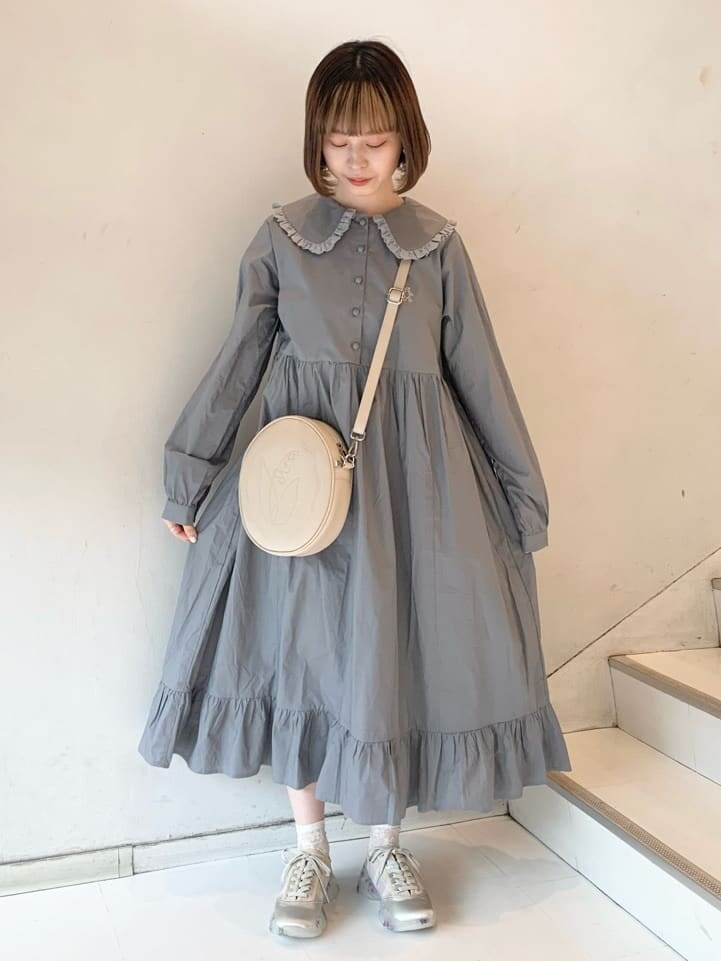 ベージュ系のカーディガン/ボレロ、ホワイト系のスニーカー、ホワイト系のショルダーバッグを着用したレディースの冬コーディネートの2枚目の写真