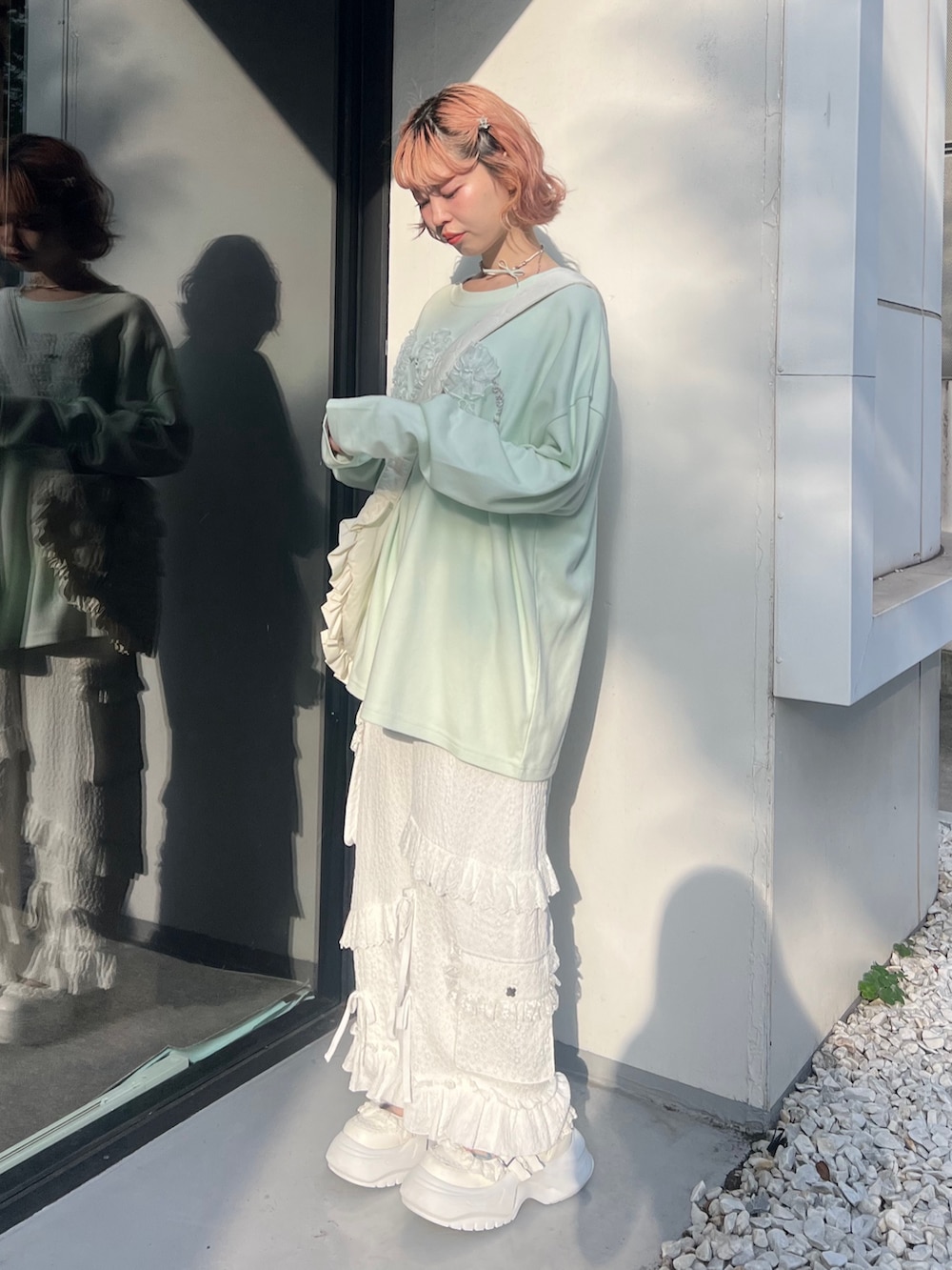 グリーン系のTシャツ/カットソー、ホワイト系のショルダーバッグ、ホワイト系のカーゴパンツを着用したレディースの夏コーディネートの2枚目の写真