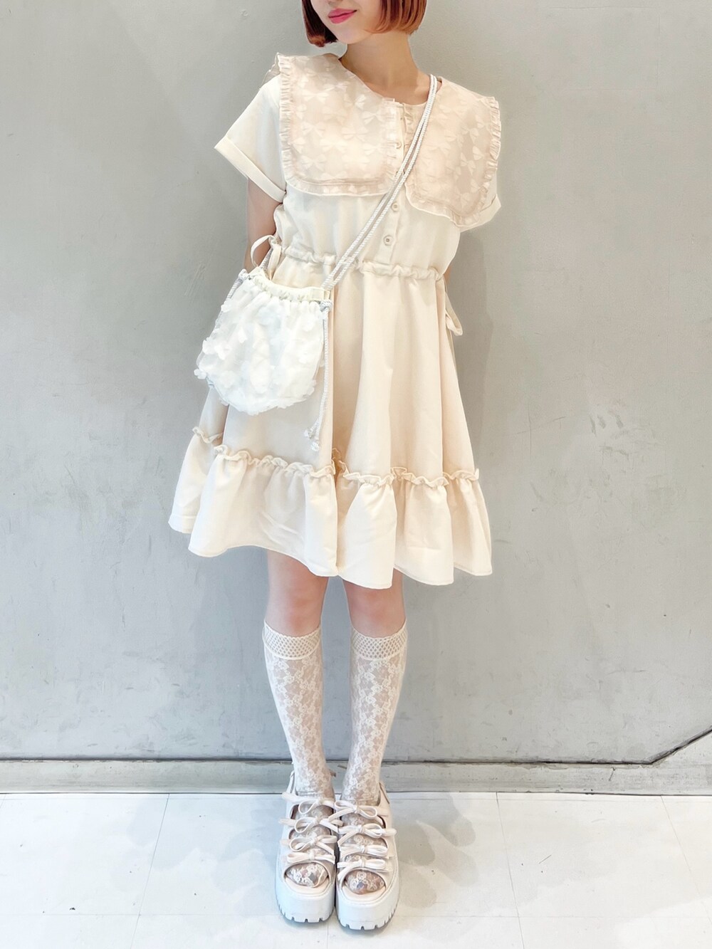 ピンク系のワンピース、ホワイト系のショルダーバッグ、ホワイト系のサンダルを着用したレディースの夏コーディネートの2枚目の写真