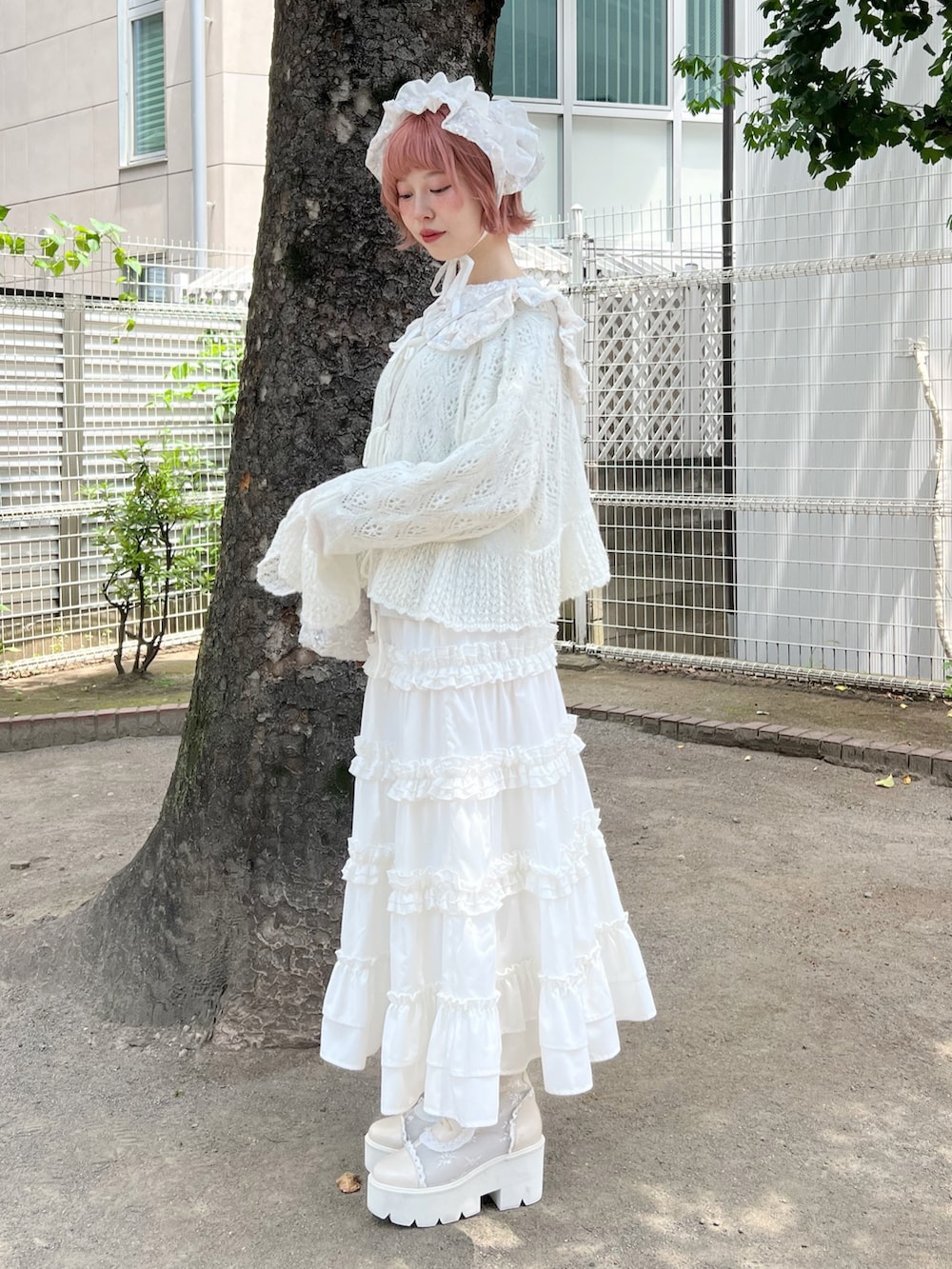 ホワイト系のハンドバッグ、ホワイト系のスカート、ホワイト系のブーツを着用したレディースの夏コーディネートの5枚目の写真