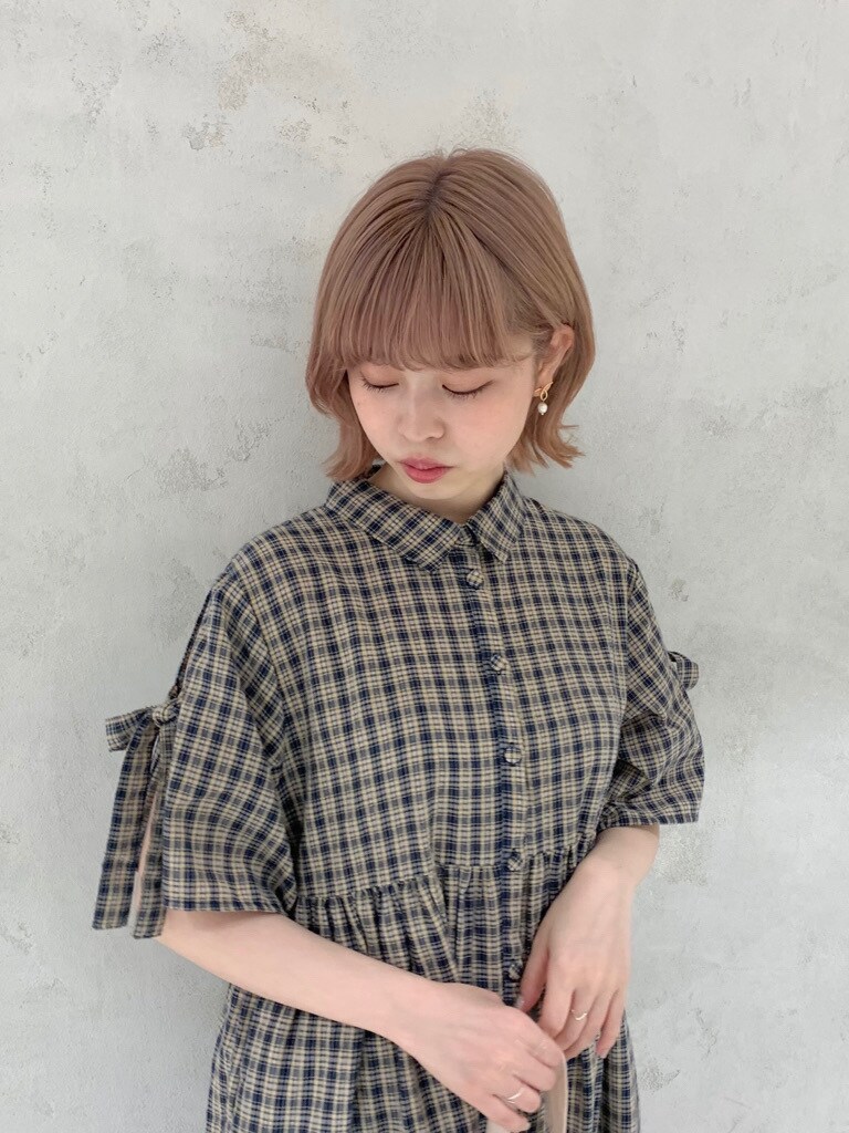 ピンク系のトートバッグ、ブルー系のワンピースを着用したレディースの春コーディネートの2枚目の写真