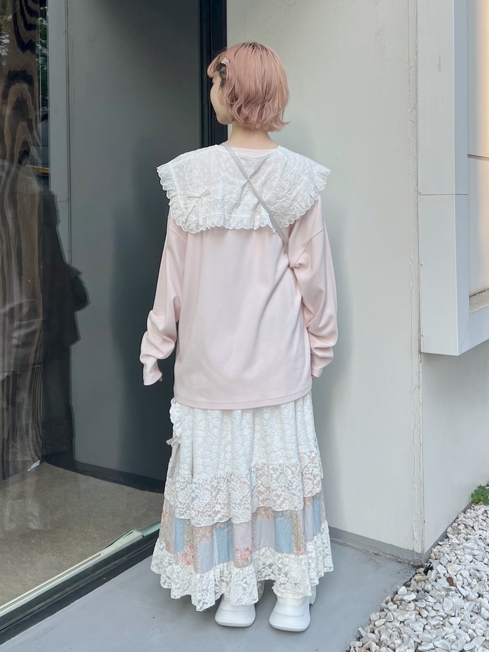 ピンク系のTシャツ/カットソー、ホワイト系のハンドバッグ、ピンク系のスカートを着用したレディースの夏コーディネートの3枚目の写真