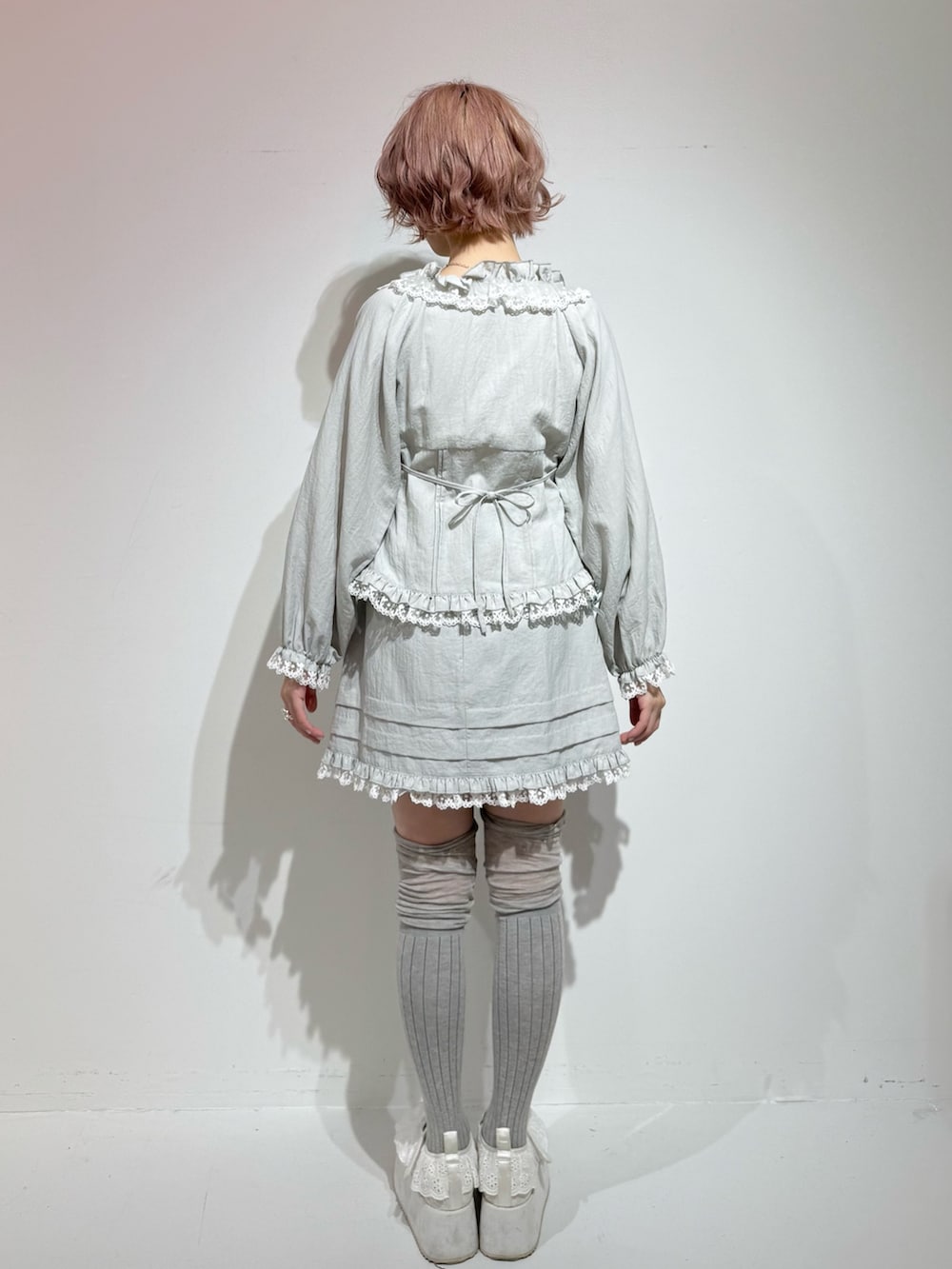 ブルー系のシャツ/ブラウス、ブルー系のスカート、ホワイト系のスニーカーを着用したレディースの冬コーディネートの4枚目の写真