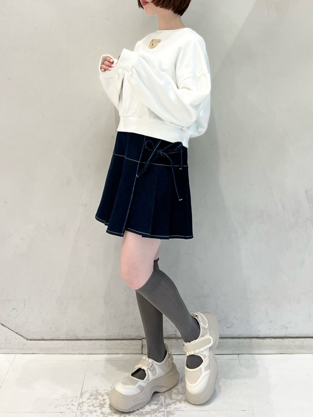 ブルー系のデニムスカート、ブルー系のブルゾン、ホワイト系のスウェットを着用したレディースの冬コーディネートの6枚目の写真