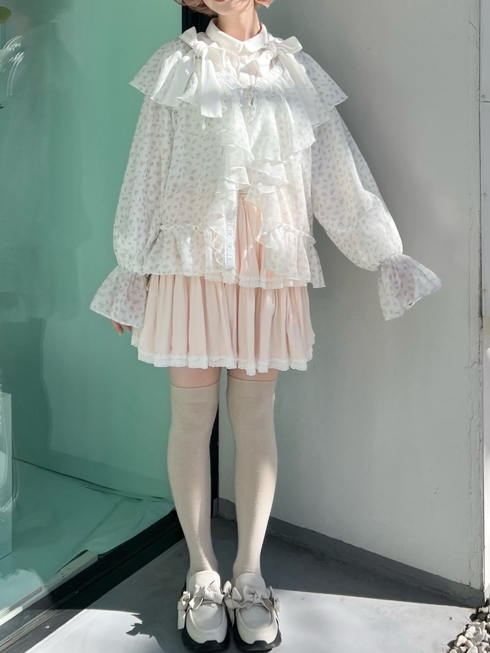 ブルー系のカーディガン/ボレロ、ピンク系のスカート、ホワイト系のスニーカーを着用したレディースの冬コーディネートの5枚目の写真